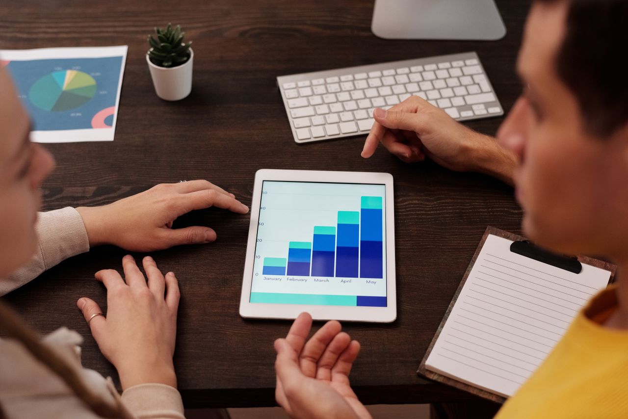 Team members reviewing digital charts on a tablet in a contemporary office environment.